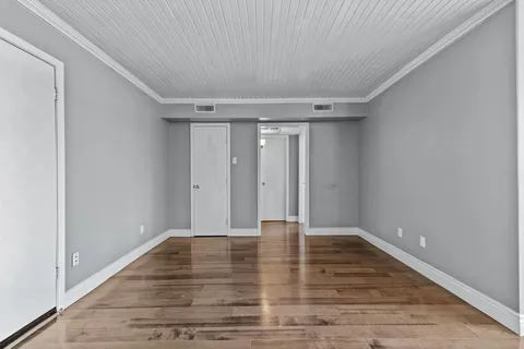 a view of an empty room with wooden floor