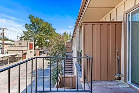 a view of a balcony with wooden floor and fence