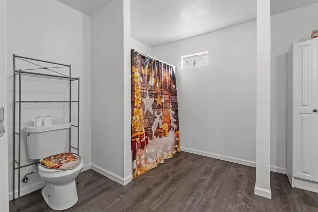 a bathroom with a toilet and a shower curtain