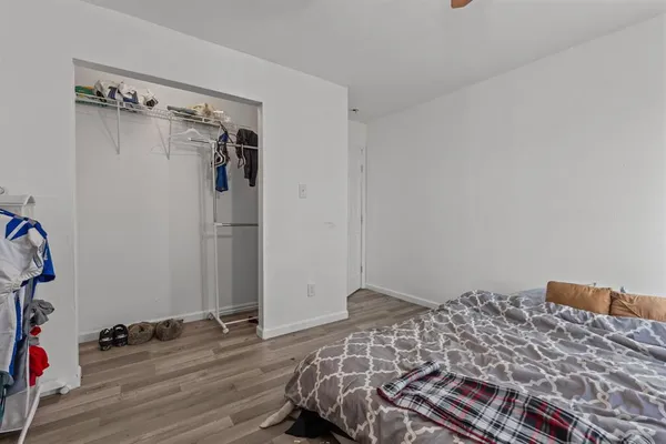 a bedroom with a bed and a wooden floor