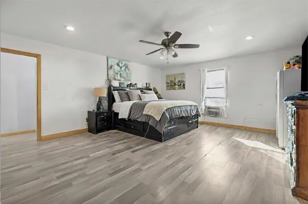 a spacious bedroom with a bed and a flat screen tv