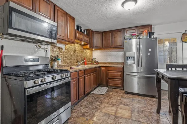 a kitchen with a stove top oven and refrigerator