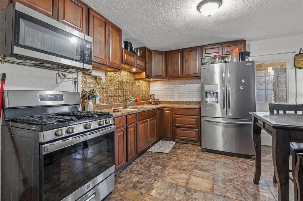 9201 Farmers Road White Settlement, TX 76108 - Photo 9 of 35 a kitchen with a stove top oven and refrigerator