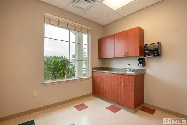 a kitchen with granite countertop a stove a sink and a microwave