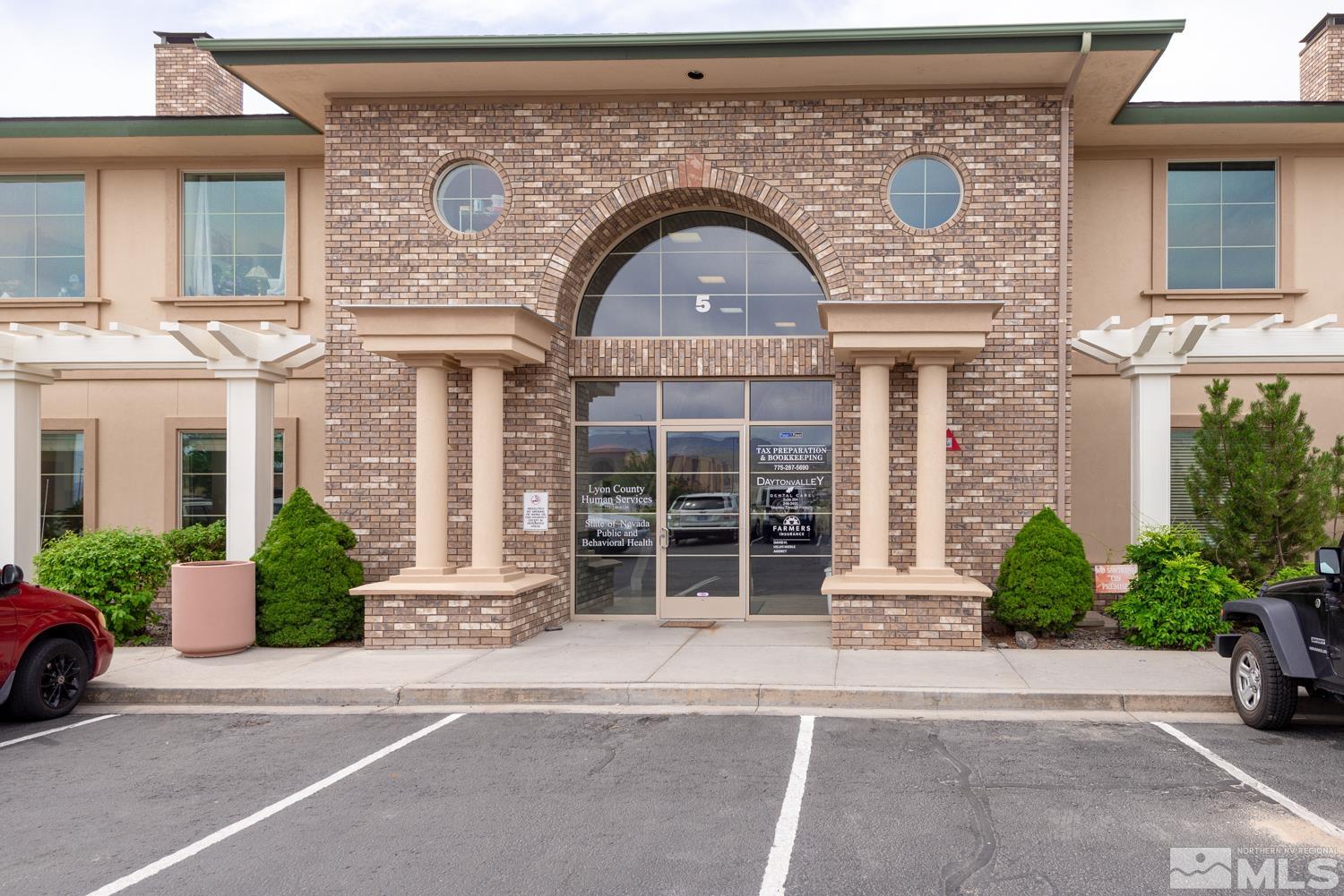 5 Pine Cone Road, Unit 102 Dayton, NV 89403 - Photo 2 of 21 front view of a brick house with a garden and plants