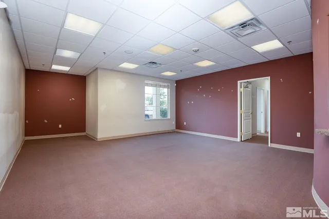 an empty room with windows and fireplace