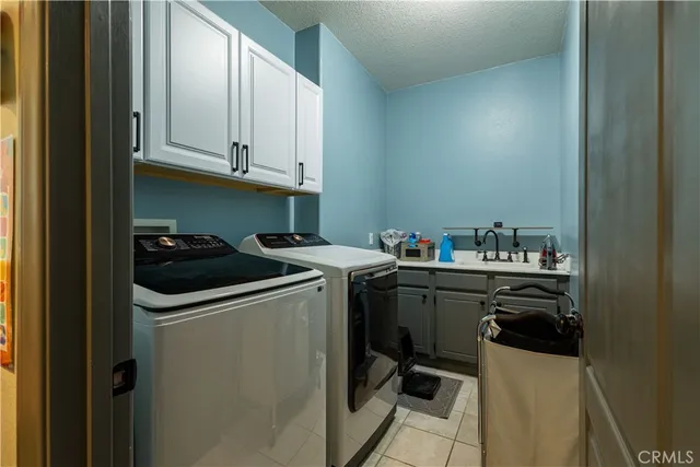 a utility room with sink dryer and washer