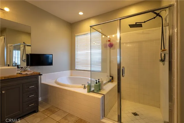 a bathroom with a tub a sink a mirror and a shower