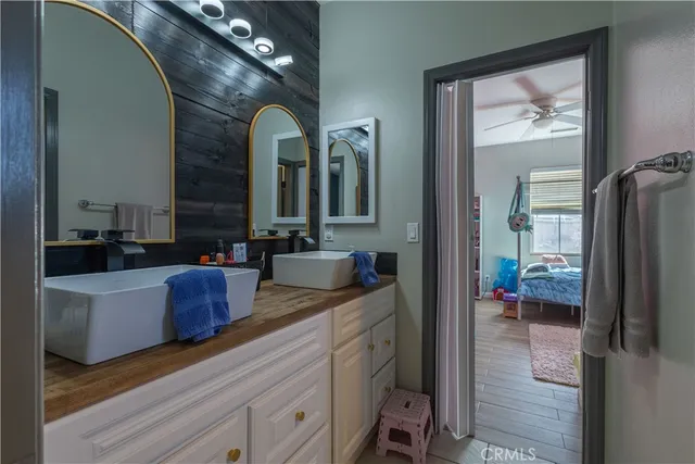 a en suite bathroom with a granite countertop sink mirror and vanity