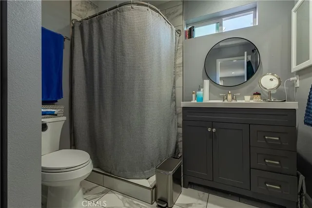 a bathroom with a toilet a sink and mirror