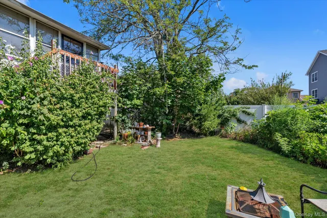 a backyard of a house with table and chairs and potted plants