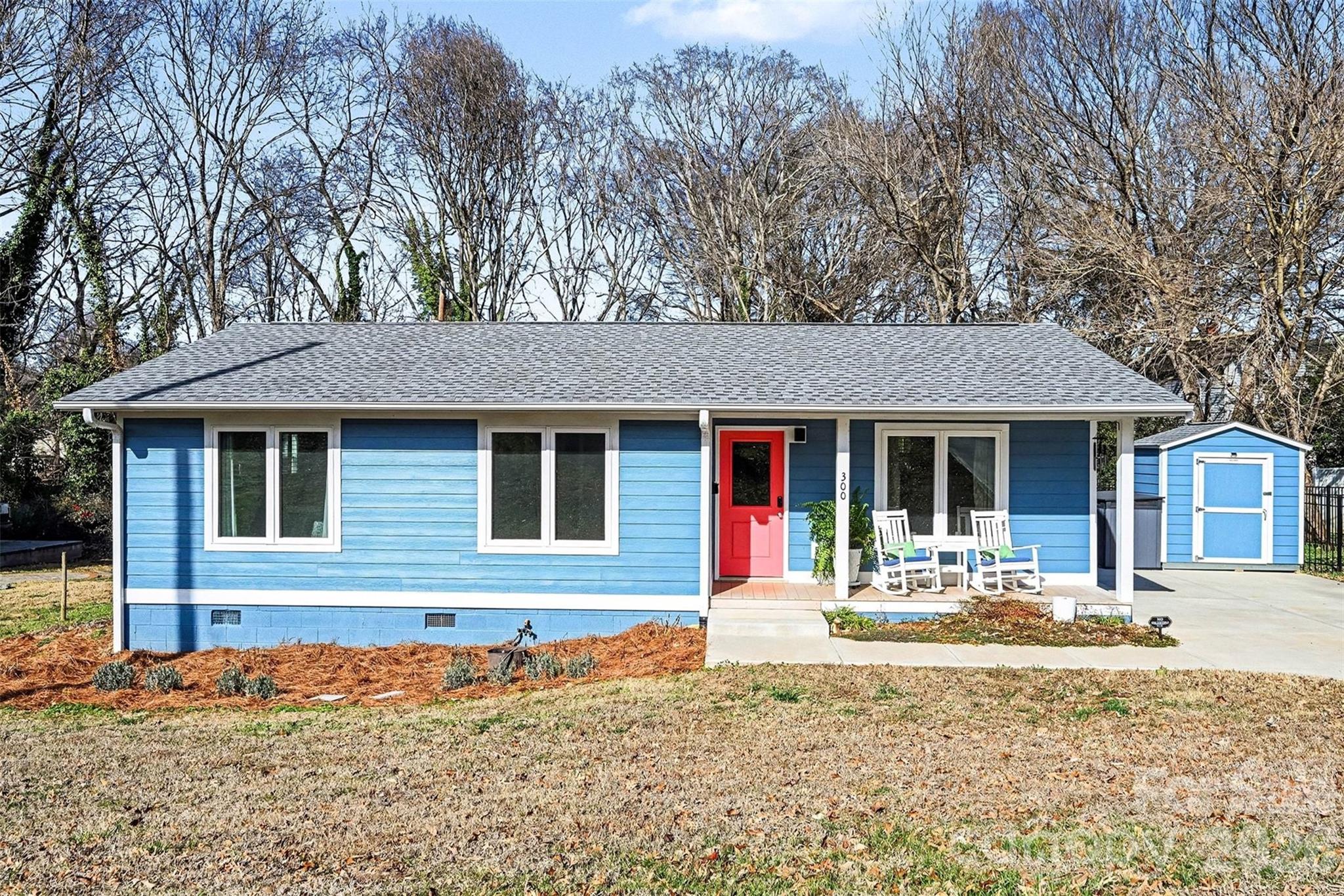 a front view of a house with a yard and tree