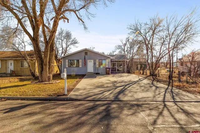 a front view of a house with a yard covered in snow