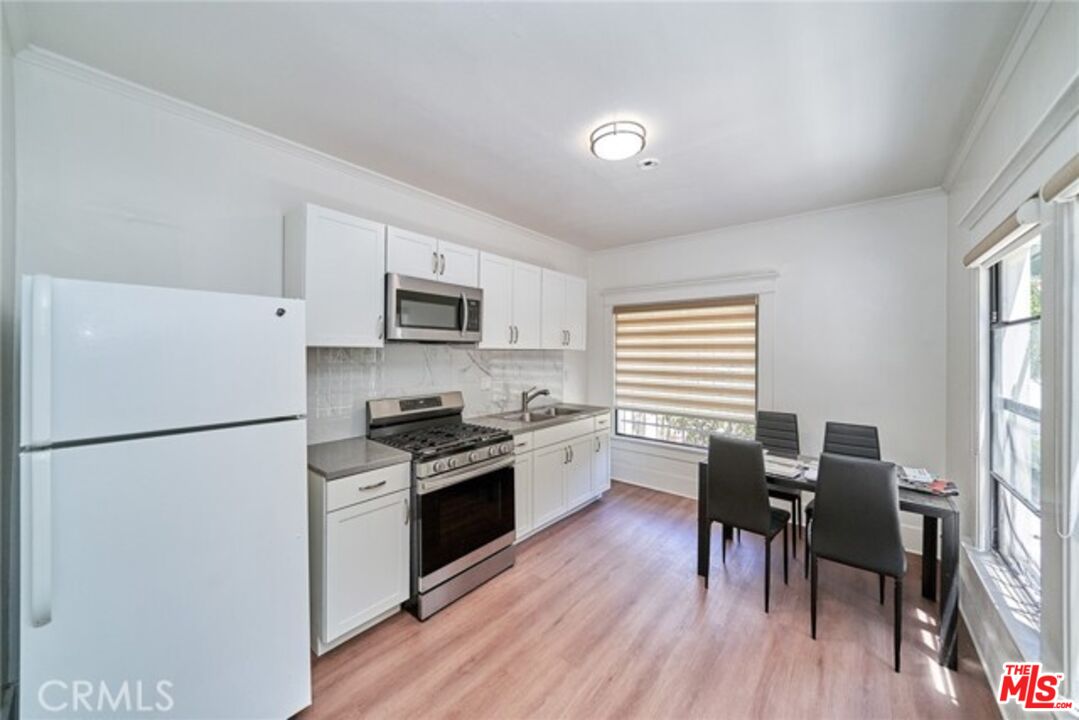 1023 South Wilton Place Los Angeles, CA 90019 - Photo 14 of 34 a kitchen with granite countertop cabinets stainless steel appliances and wooden floor