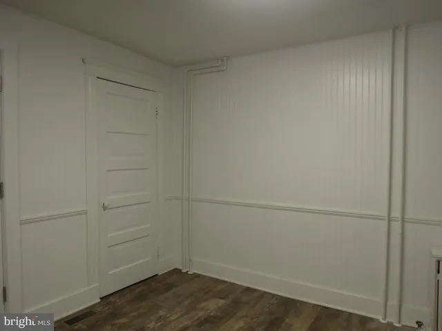 a view of a house with a yard potted plants and a bench