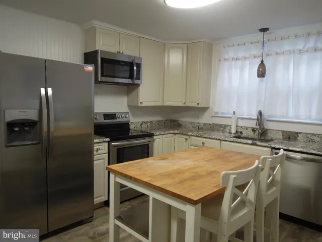 a kitchen with a sink a microwave a stove and refrigerator
