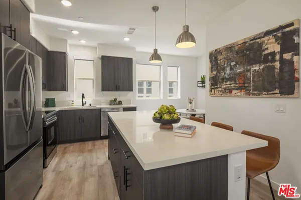 a kitchen with stainless steel appliances a sink a stove a refrigerator and cabinets