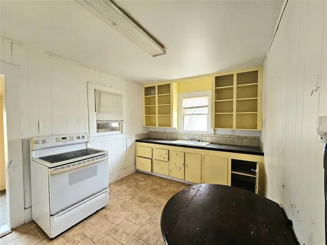 a kitchen with granite countertop cabinets stainless steel appliances and a window
