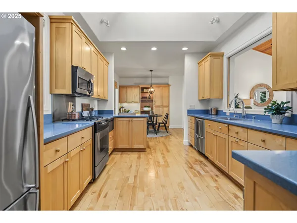 a kitchen with stainless steel appliances granite countertop sink stove refrigerator and cabinets