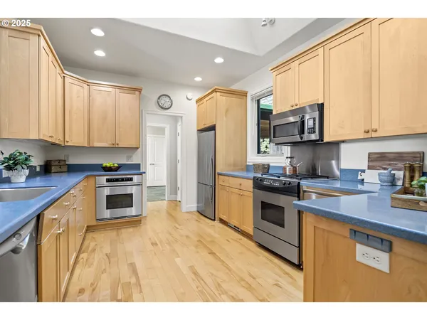 a kitchen with stainless steel appliances granite countertop a stove a sink and a refrigerator