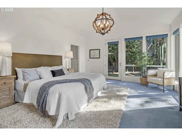 a bedroom with a large bed and a chandelier
