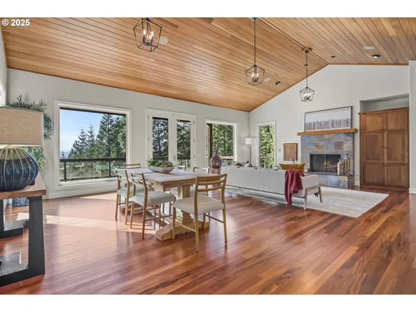 a dining hall with stainless steel appliances granite countertop a stove a refrigerator a dining table and chairs with wooden floor