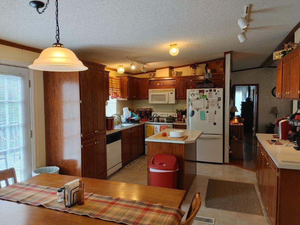 365 Elamsville Road Stuart, VA 24171 - Photo 8 of 27 a kitchen with stainless steel appliances granite countertop a refrigerator a sink dishwasher a stove and a dining table with wooden floor