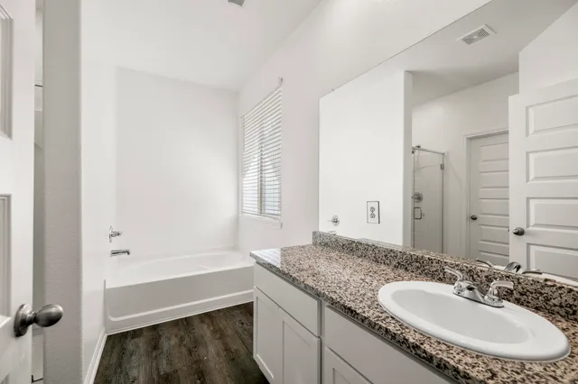 a bathroom with a granite countertop sink and a mirror