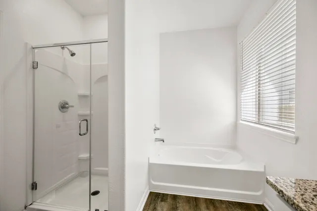 a bathroom with a shower and a bath tub