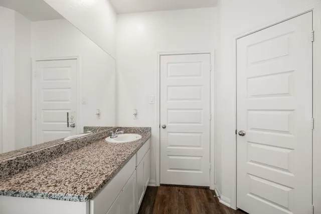a bathroom with a granite countertop sink and a mirror