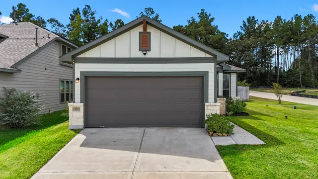 a front view of a house with a yard and potted plants