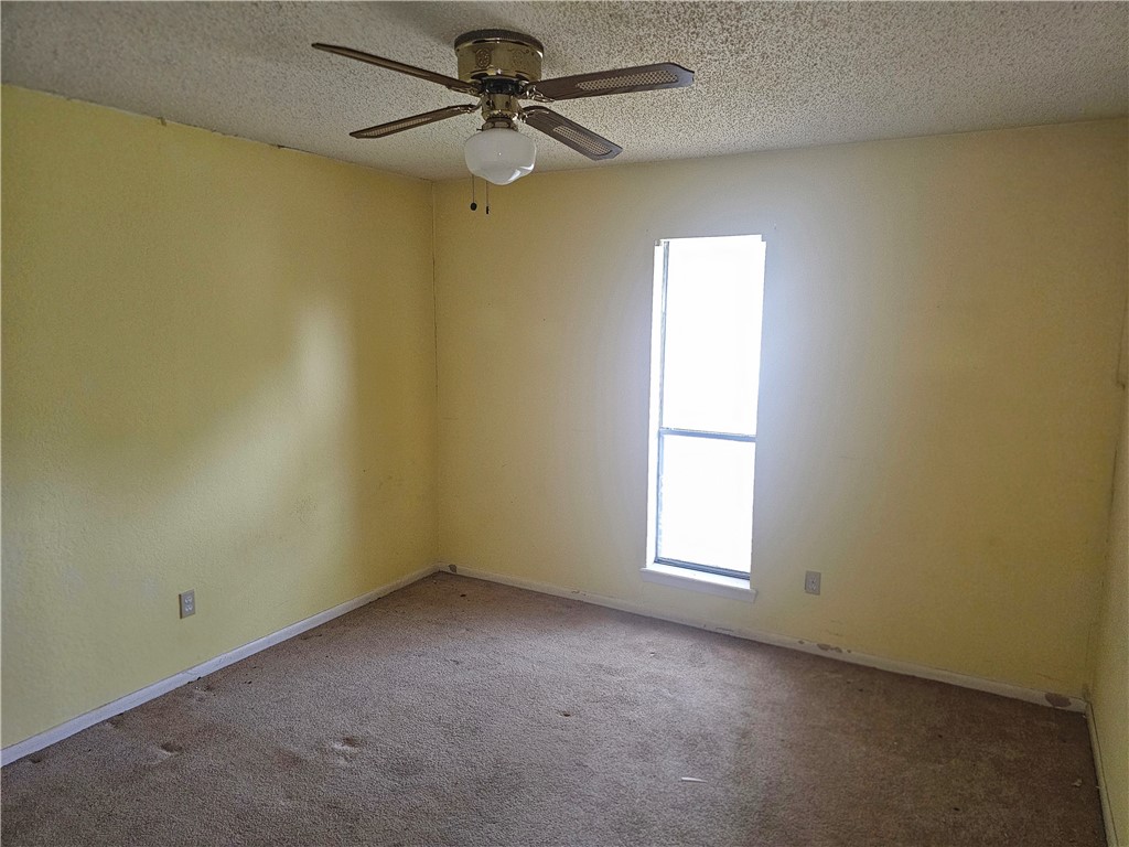 4961 Shadowbend Drive Corpus Christi, TX 78413 - Photo 13 of 16 an empty room with a window and a fan