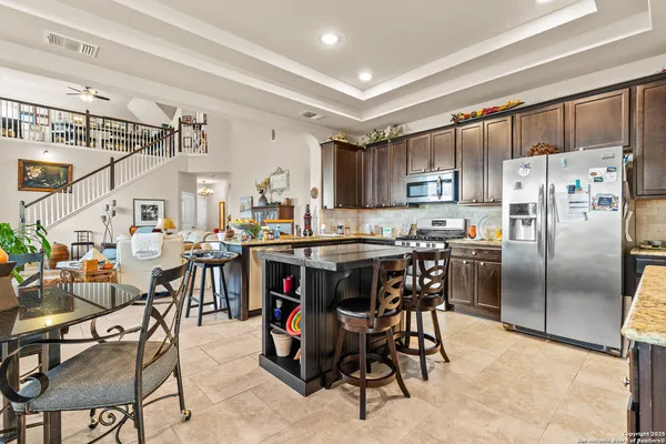 a kitchen with stainless steel appliances a table chairs refrigerator and a window