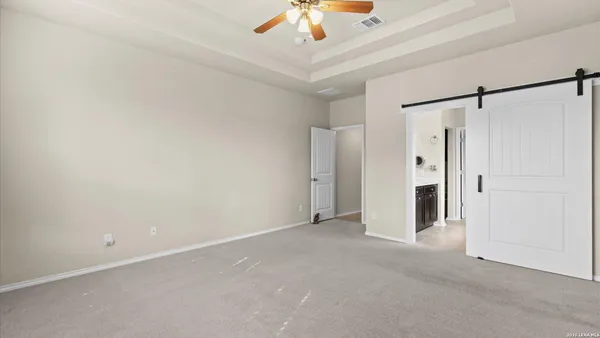 an empty room with a ceiling fan and shower