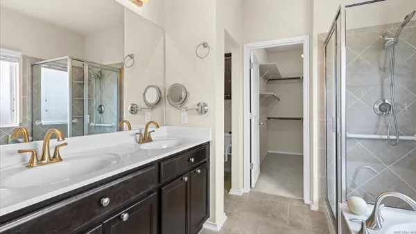 a bathroom with a granite countertop sink a mirror and a shower