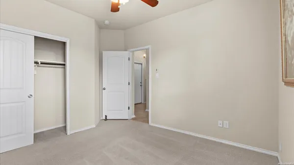an empty room with closet and windows