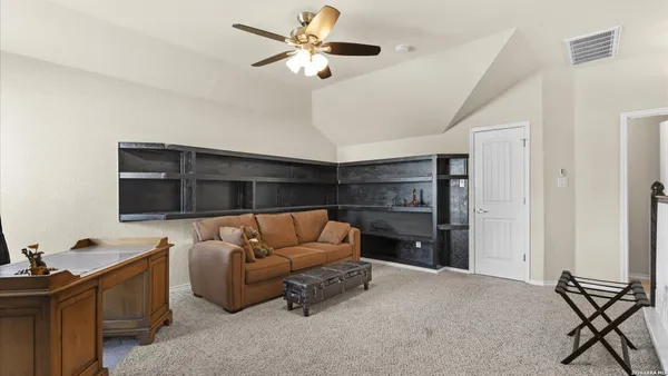 a living room with furniture ceiling fan and a window
