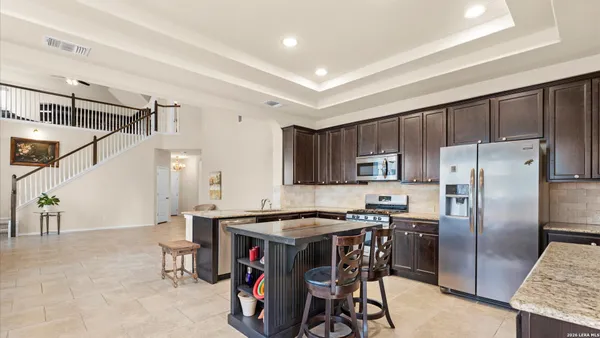 a kitchen with stainless steel appliances granite countertop a stove a refrigerator and a sink