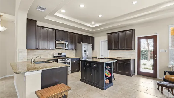 a kitchen with a sink stove top oven and refrigerator