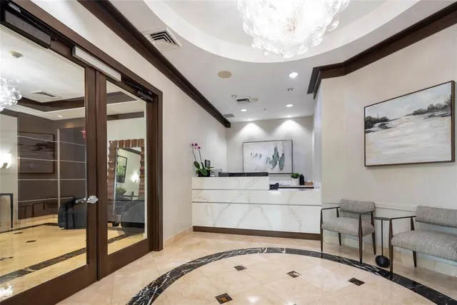 a front view of multi story residential apartment building with yard and parking space