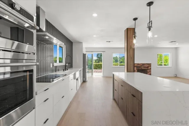 a large kitchen with kitchen island a stove a sink and a refrigerator