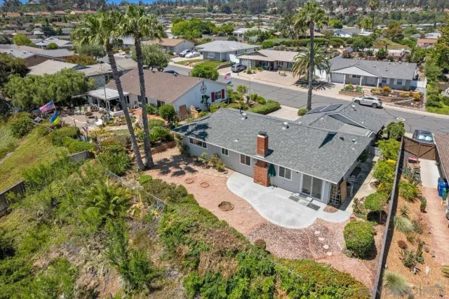an aerial view of residential houses with outdoor space and trees