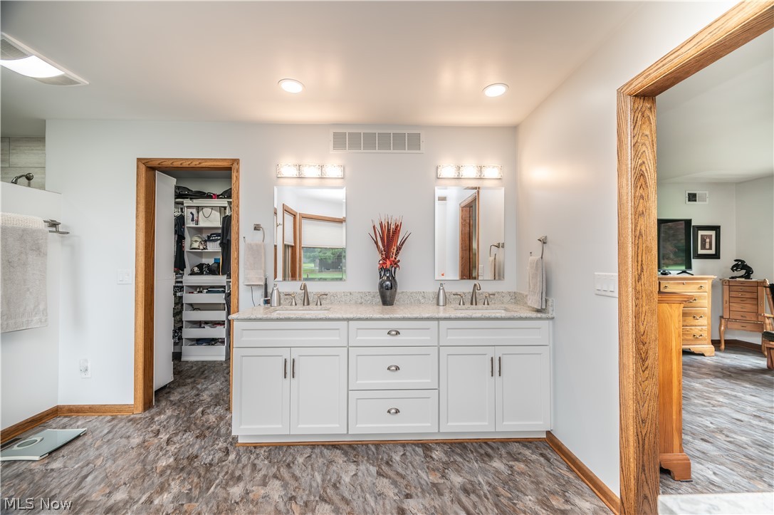 405 Airport Road Northwest Warren, OH 44481 - Photo 27 of 50 Bathroom featuring a dual vanity with white cabinetry, a light-toned countertop, and individual mirrors with task lighting