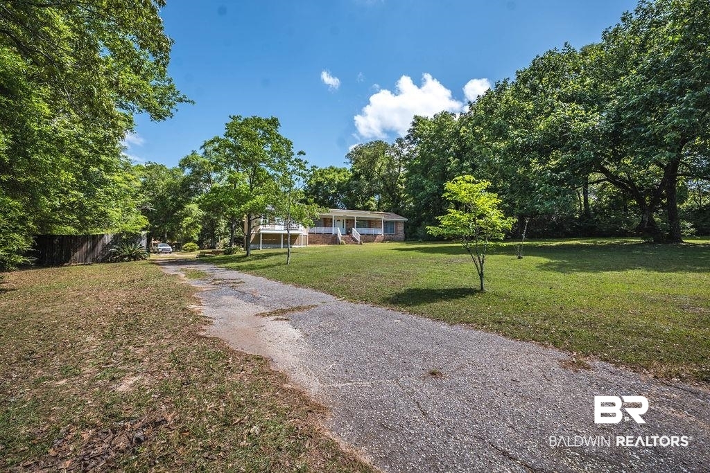 11901 Old Moffat Road Wilmer, AL 36587 - Photo 31 of 39 View of front facade with a front yard, driveway, and view of wooded area