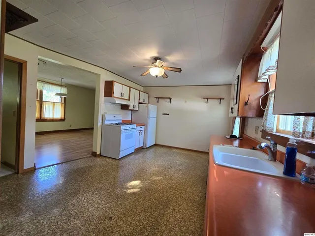 a large kitchen with granite countertop a stove and a large window