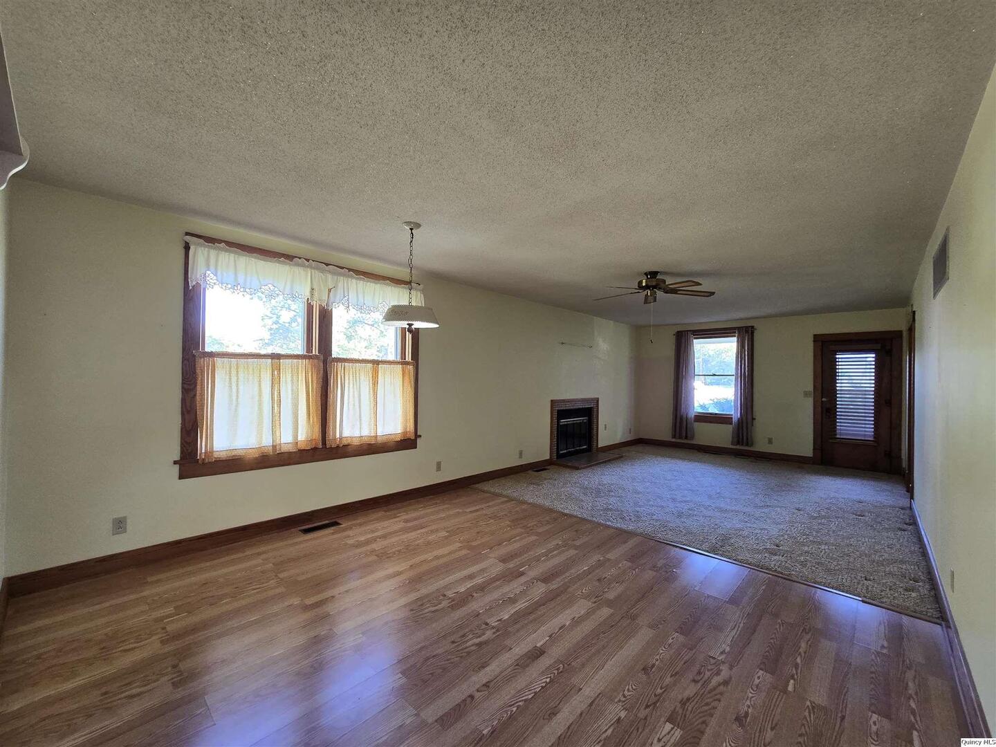 401 Ravenscroft Avenue Versailles, IL 62378 - Photo 6 of 14 an empty room with wooden floor and windows
