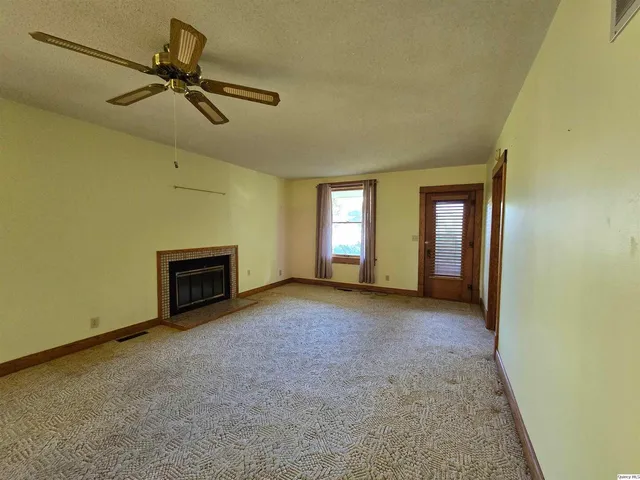 an empty room with a fireplace and windows