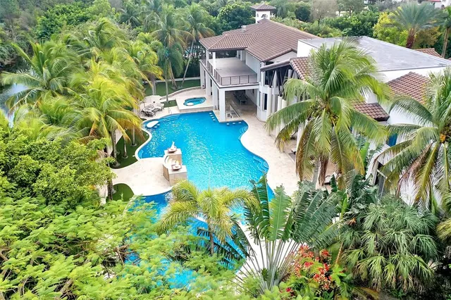 a aerial view of a house with table and chairs under an umbrella