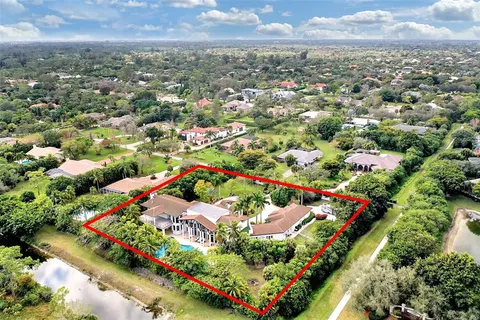an aerial view of residential houses with outdoor space and trees