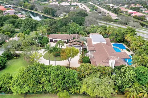an aerial view of a house with a yard and lake view